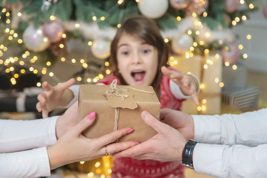 Child girl parents give presents for christmas. Selective focus. Holiday.