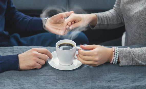 Man and woman at the table with a cup of coffee. Selective focus. People.