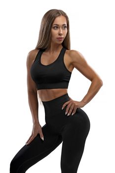 Aesthetics of a healthy and fit female body in yoga fitness basic sportswear. Motivation, sports lifestyle. Posing on a white cyclorama