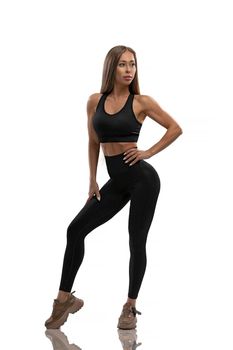 Aesthetics of a healthy and fit female body in yoga fitness basic sportswear. Motivation, sports lifestyle. Posing on a white cyclorama