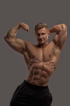 Professional bodybuilder in a dry filled form in a large weight category posing on a black background. Sports lifestyle.