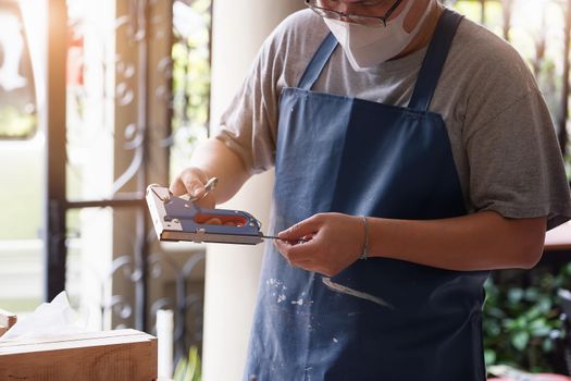 Entrepreneur Woodwork holding a Tacker to assemble the wood pieces as the customer ordered