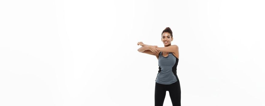 Sport, training, lifestyle and Fitness concept - Full-length portrait of beautiful happy African American woman stretching hands. Isolated on white studio background