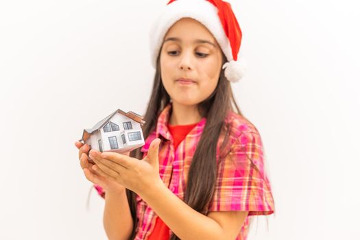 little girl holding a little model of the house in christmas