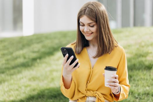 People portraits and technology concept. Appealing young elegant caucasian woman using social media application on smartphone text messages receive news smiling outdoor.