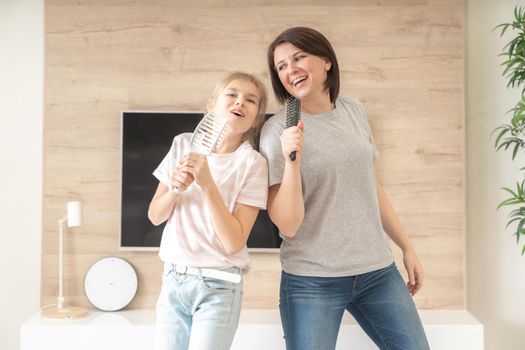 mother and daughter singing with hairbrushes