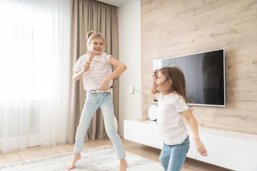 Two sisters having fun dancing in living room
