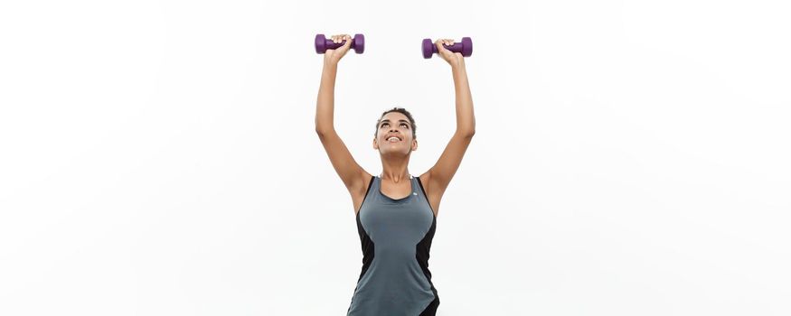 Healthy and Fitness concept - Beautiful American African lady in fitness clothes workout with dumbbell. Isolated on white background