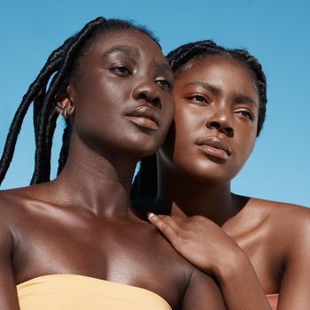 Cropped shot of two attractive young women posing outside.