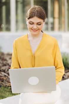 Caucasian freelance business woman casual wear using laptop working call video conference with customer in workplace. Happy young girl sitting on bench do job in internet.