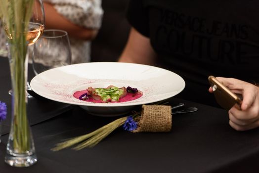 Man eats soup with pickled beets. and tongue. Preparation of borscht. . Polish cuisine. Healthy food. Black tablecloth