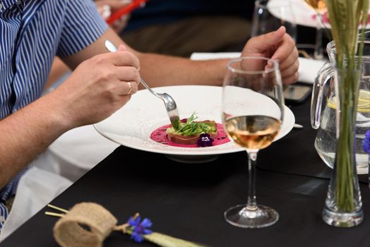 Man eats soup with pickled beets. and tongue. Preparation of borscht. . Polish cuisine. Healthy food. Black tablecloth