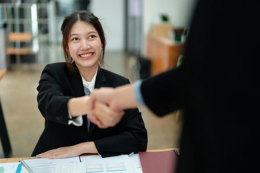 Asian entrepreneurs handshakes to congratulate the agreement between the two companies to enhance investment and financial strength. deal concept.