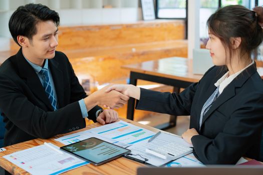 Asian entrepreneurs handshakes to congratulate the agreement between the two companies to enhance investment and financial strength. deal concept.