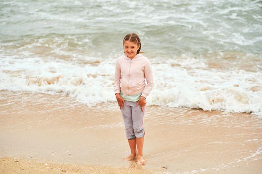 Happy child playing in the sea. Kid girl having fun at the beach. Summer vacation and active lifestyle concept