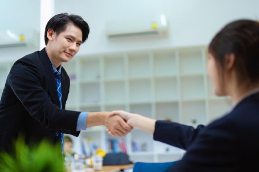 Asian entrepreneurs handshakes to congratulate the agreement between the two companies to enhance investment and financial strength. deal concept.