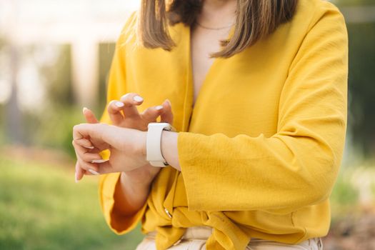 Close up of woman hand with smartwatch. Checking incoming notification on smart watch. Scrolling display on smartwatch. Caucasian girl using smartwatch.