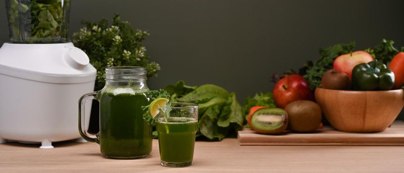 Delicious vegetable smoothie on wooden table with fresh vegetables and blender. Healthy food concept.