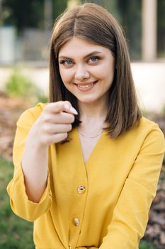 Hey you, come here. European ukraininan girl pointing index finger at camera inviting with hand gesture. Young ethnic happy woman calling to showing something and speaking body language.