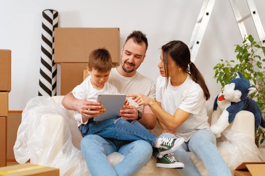 Portrait of happy family with cardboard boxes in new house at moving day, close up