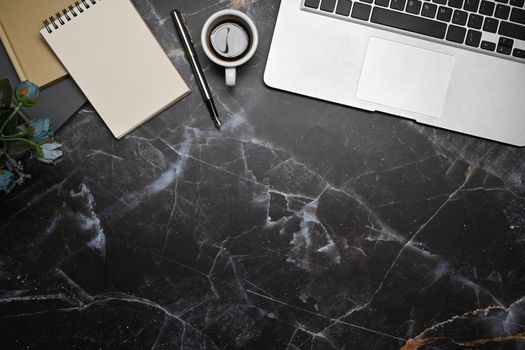 Stylish workspace with laptop computer, notepad and coffee cup on marble background.