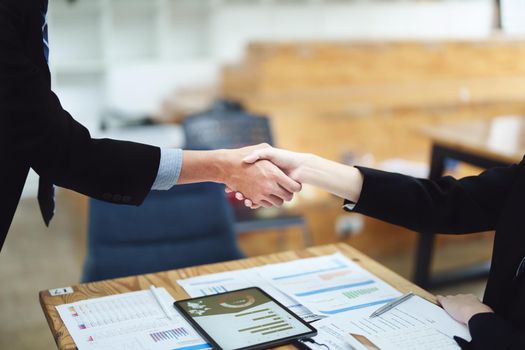 Asian entrepreneurs handshakes to congratulate the agreement between the two companies to enhance investment and financial strength. deal concept.