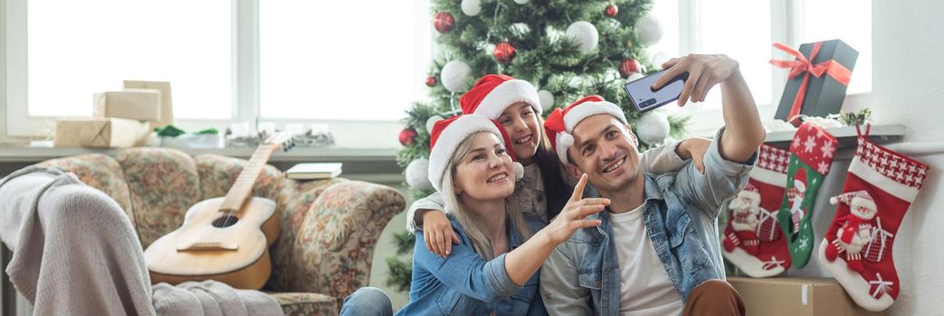 family near the Christmas tree in their living room.