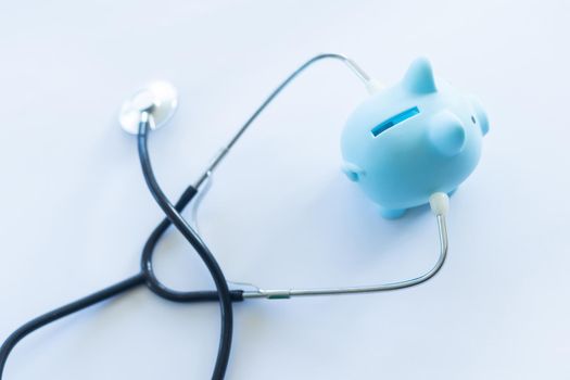 Piggy bank with stethoscope isolated on white