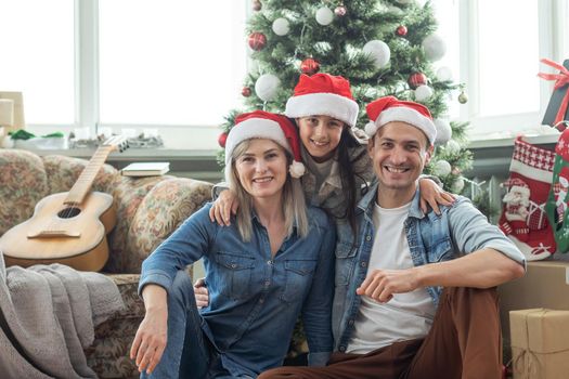 family having fun and playing together near Christmas tree indoors