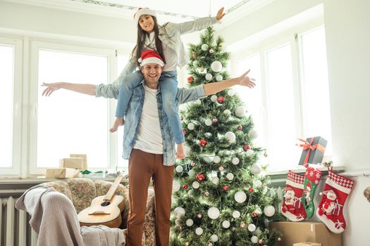 father and daughter near the Christmas tree.