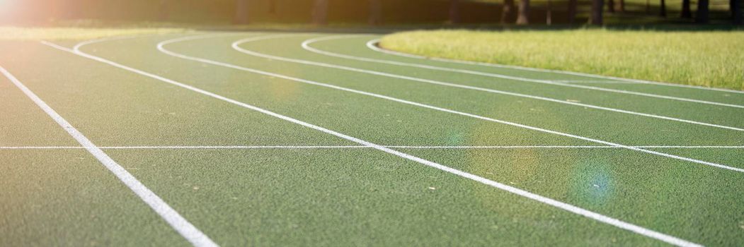 Running track at the stadium. Rubber coated green. Running track in the park outdoors, summer.