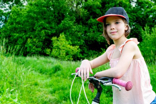 a child girl has damaged a bicycle wheel and is making repairs photo without processing. High quality photo