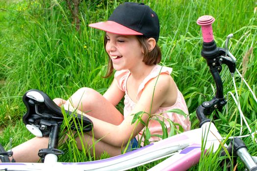 a child girl has damaged a bicycle wheel and is making repairs photo without processing. High quality photo