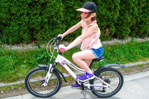 a child girl has damaged a bicycle wheel and is making repairs photo without processing. High quality photo