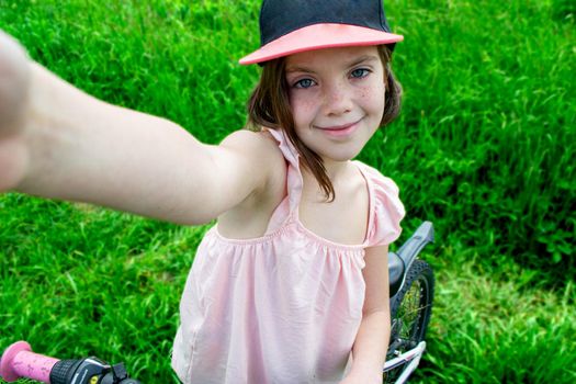 a child girl has damaged a bicycle wheel and is making repairs photo without processing. High quality photo