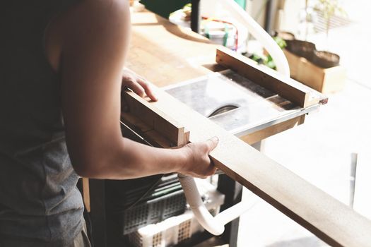 Woodworking operators are using plank cutting machines to assemble and build wooden tables for customers