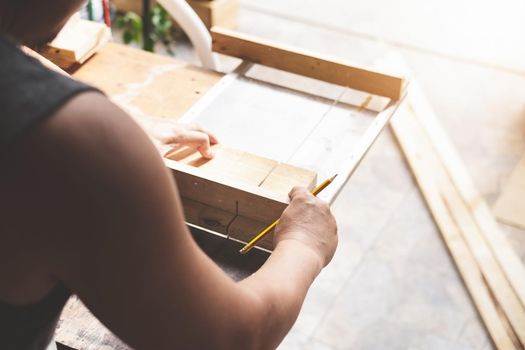 Woodworking practitioners use saw blades to cut wood pieces to assemble and build wooden tables for their clients.