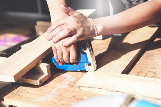 Entrepreneur Woodwork holding a Tacker to assemble the wood pieces as the customer ordered