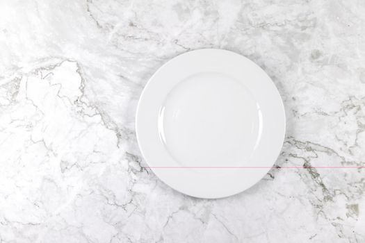 A dinner plate on a white and grey marble surface