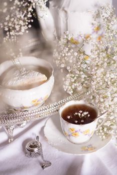white still life with cheesecake gypsophila and cup of tea, light and airy, High quality photo,table setting for tea drinking in the English style