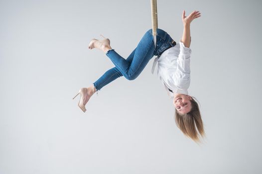 Caucasian woman in casual clothes on an aerial hoop