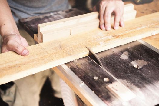 Woodworking operators are using plank cutting machines to assemble and build wooden tables for customers