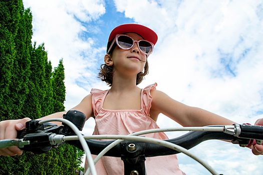 a child girl has damaged a bicycle wheel and is making repairs photo without processing. High quality photo