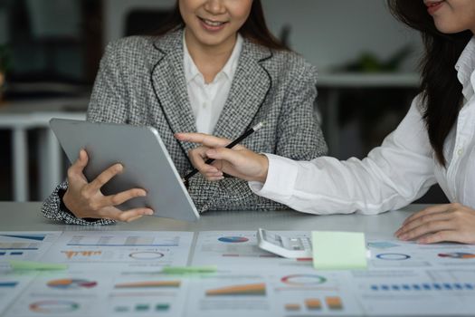 Fund managers team consultation and discuss about analysis Investment stock market by digital tablet on wooden desk in office