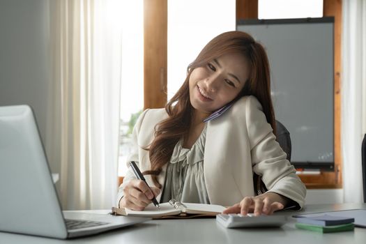 Busy business accountant woman making call phone in office and business working background, tax, accounting, statistics and analytic research concept.