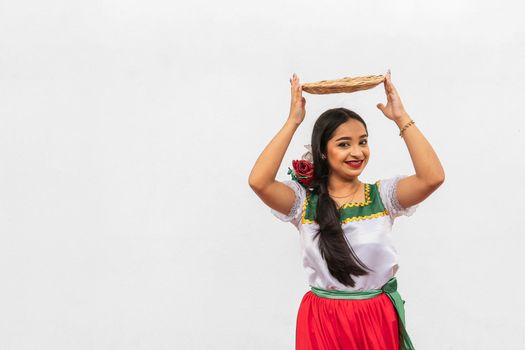 Portrait of latin young girl on white background in traditional dress