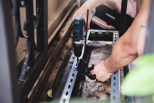 do it yourself concept, Craftsmen use electric drills to assemble old iron parts. Make a shelf on your free weekend