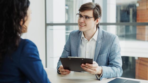HR male manager shaking hand to female candidate after having job interview in modern office indoors