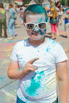 Novokuznetsk, Kemerovo region, Russia - June 12, 2022 :: Boy with colorful face painted with holi powder having fun outdoors.