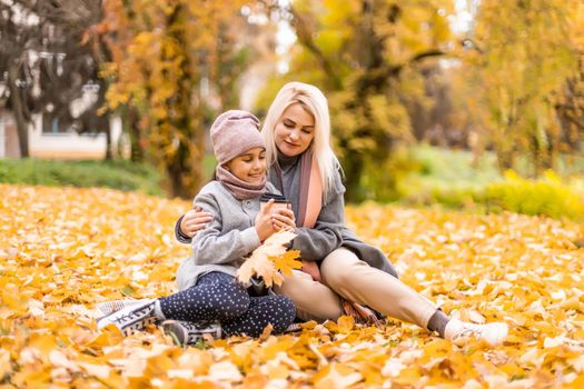 Mother and daughter in autumn yellow park